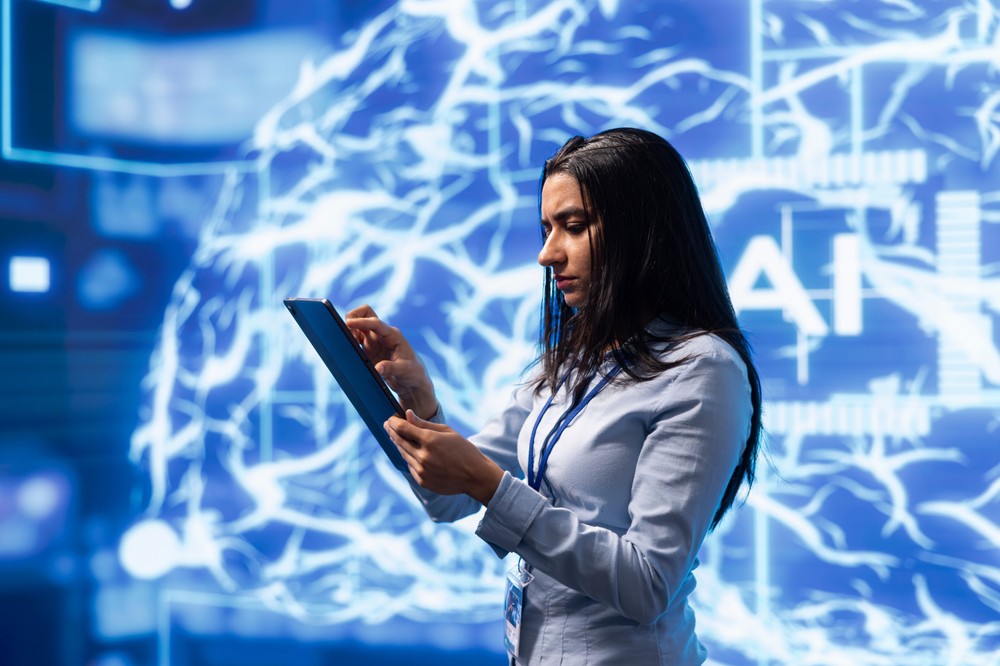 Indian woman using a tablet on stage with an AI-inspired background